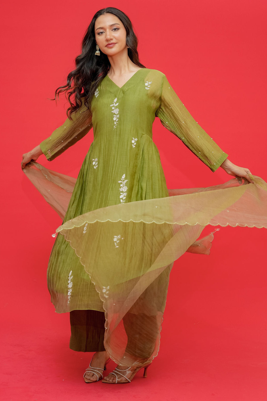 Woman in a green traditional outfit with a red background