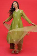 Woman in a green traditional outfit with a red background