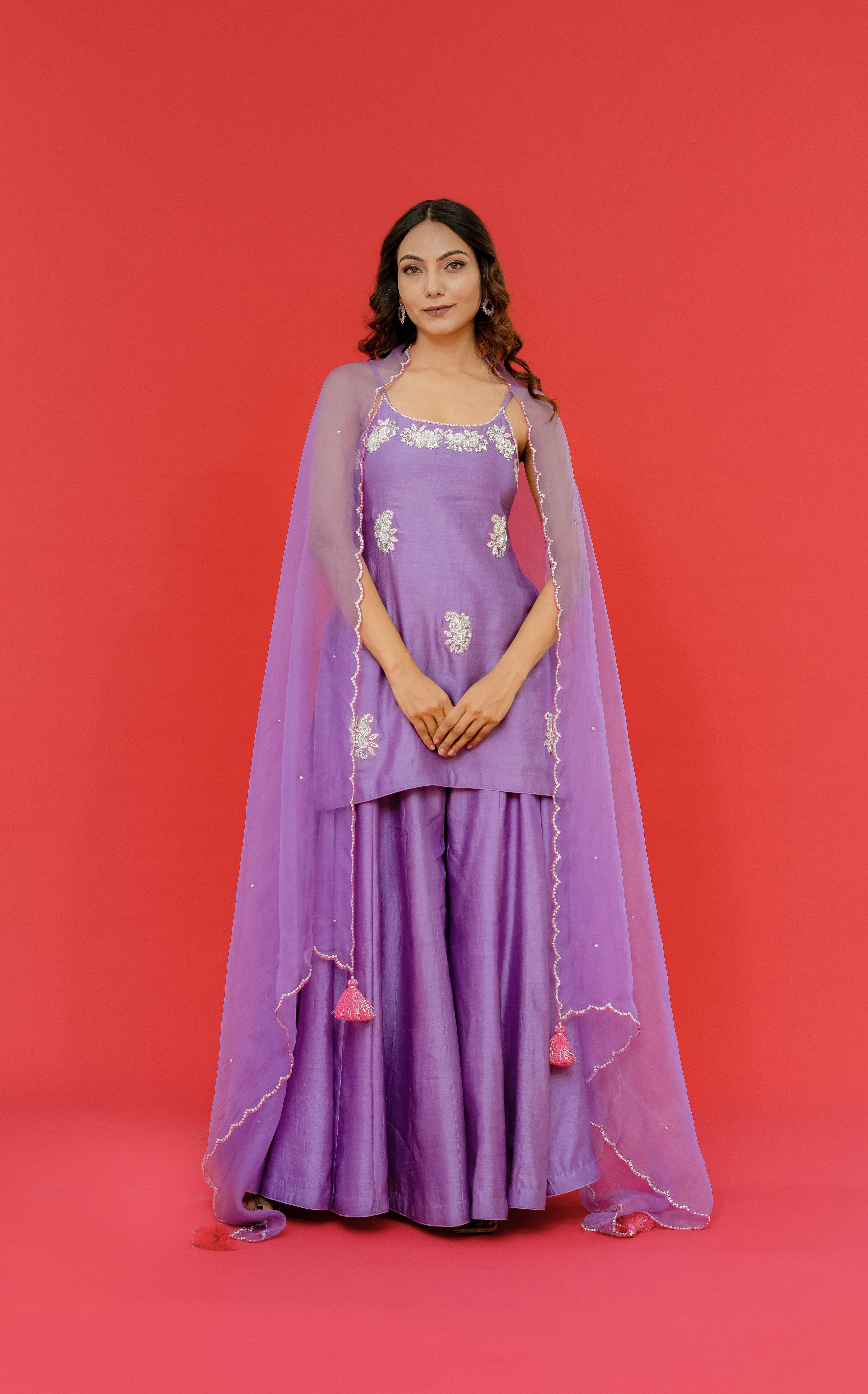 Woman wearing a purple traditional outfit with a red background
