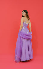 Woman in a purple gown with floral details on a red background