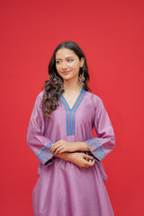 Woman wearing a purple dress with blue embroidery against a red background