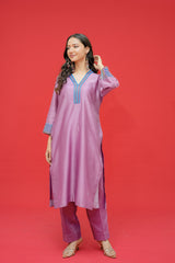 Woman wearing a pink traditional outfit with blue accents on a red background