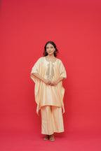 Woman wearing a peach-colored outfit against a red background