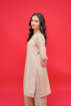 Woman wearing a beige outfit against a red background