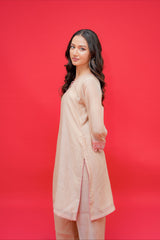 Woman wearing a beige outfit against a red background