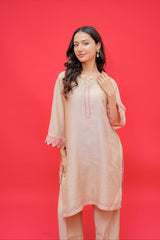Beige embroidered straight kurta with matching palazzo pants featuring pink lace cuff detailing for women.