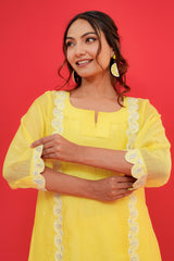 Woman wearing a yellow outfit with white lace details against a red background