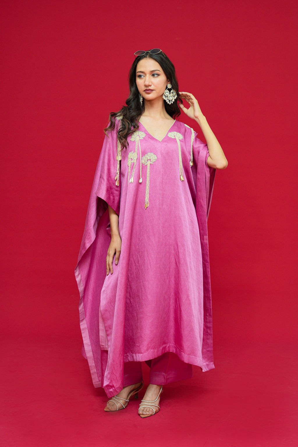 Woman wearing a pink traditional outfit with gold accents on a red background
