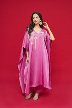 Woman wearing a pink traditional outfit with gold accents on a red background