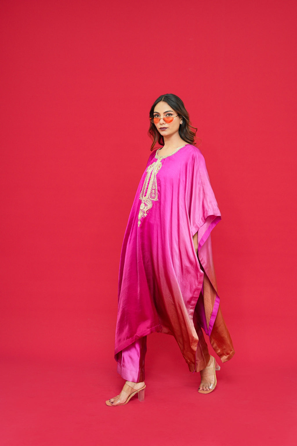 Woman wearing a Nyasa Silk Ombre Kaftan Set with a red background