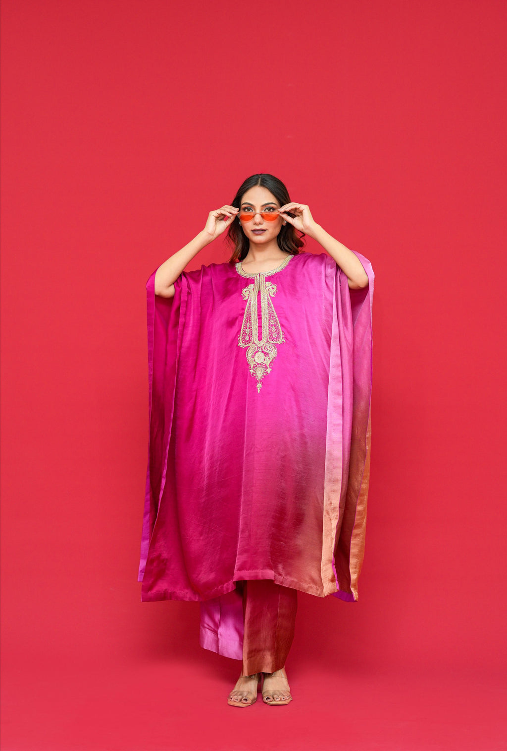 Woman wearing a pink and purple traditional outfit against a red background