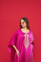 Woman wearing a pink traditional outfit with intricate designs on a red background