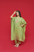 Woman wearing a Olive Green Linen Satin Kaftan Set  with a red background