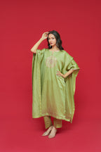 Woman wearing a Olive Green Linen Satin Kaftan Set  with a red background
