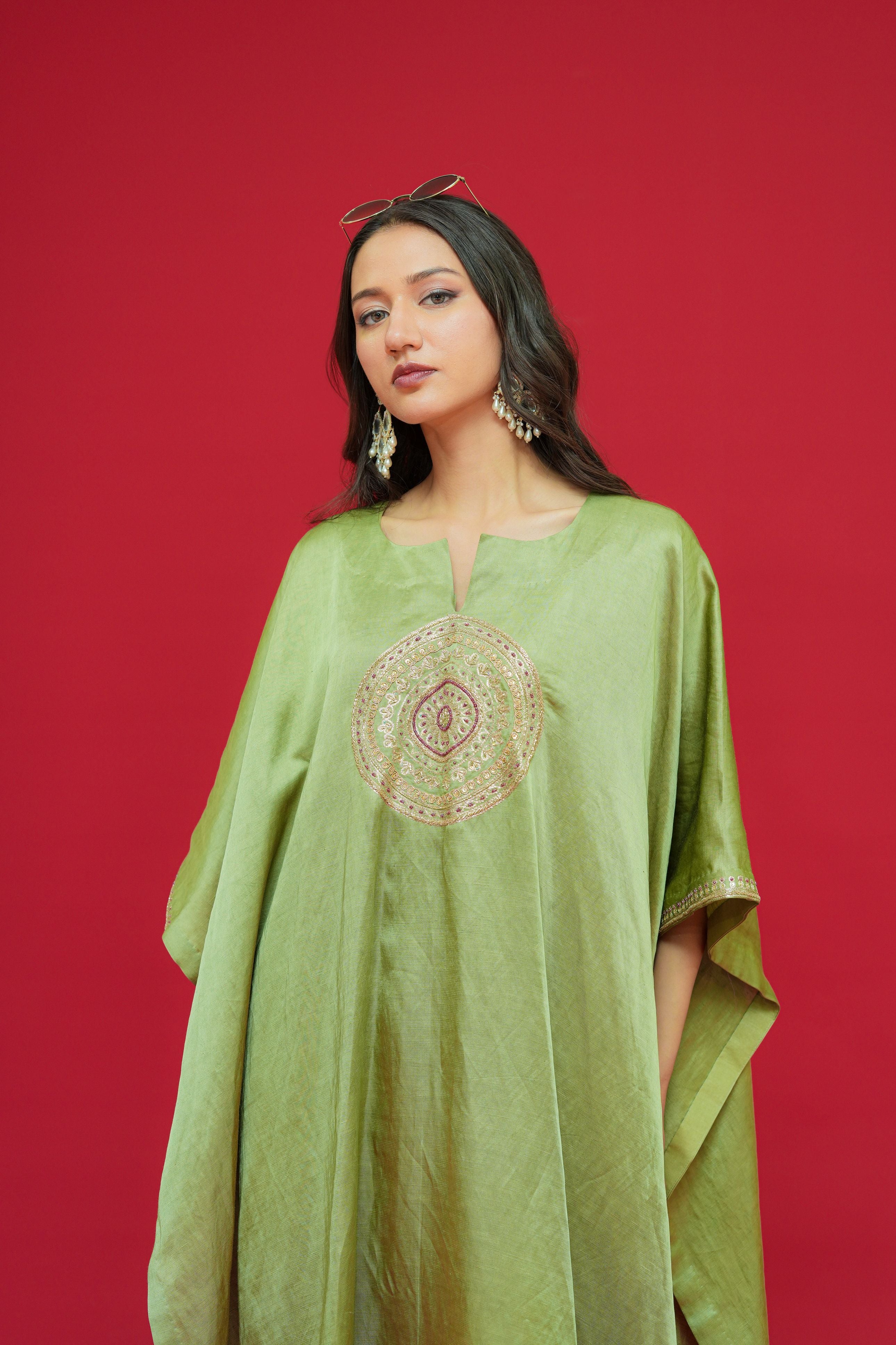 Woman wearing a Olive Green Linen Satin Kaftan Set  against a red background