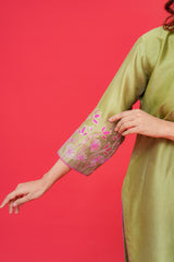Green dress with floral embroidery on a red background
