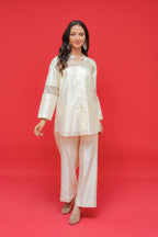 Woman wearing a cream-colored traditional outfit against a red background
