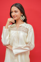 Woman wearing a white lace-trimmed blouse against a red background