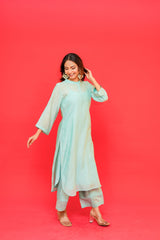 Woman wearing a light blue traditional outfit on a red background