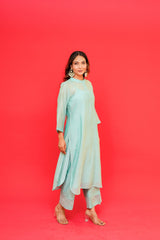 Woman wearing a light blue traditional outfit against a red background