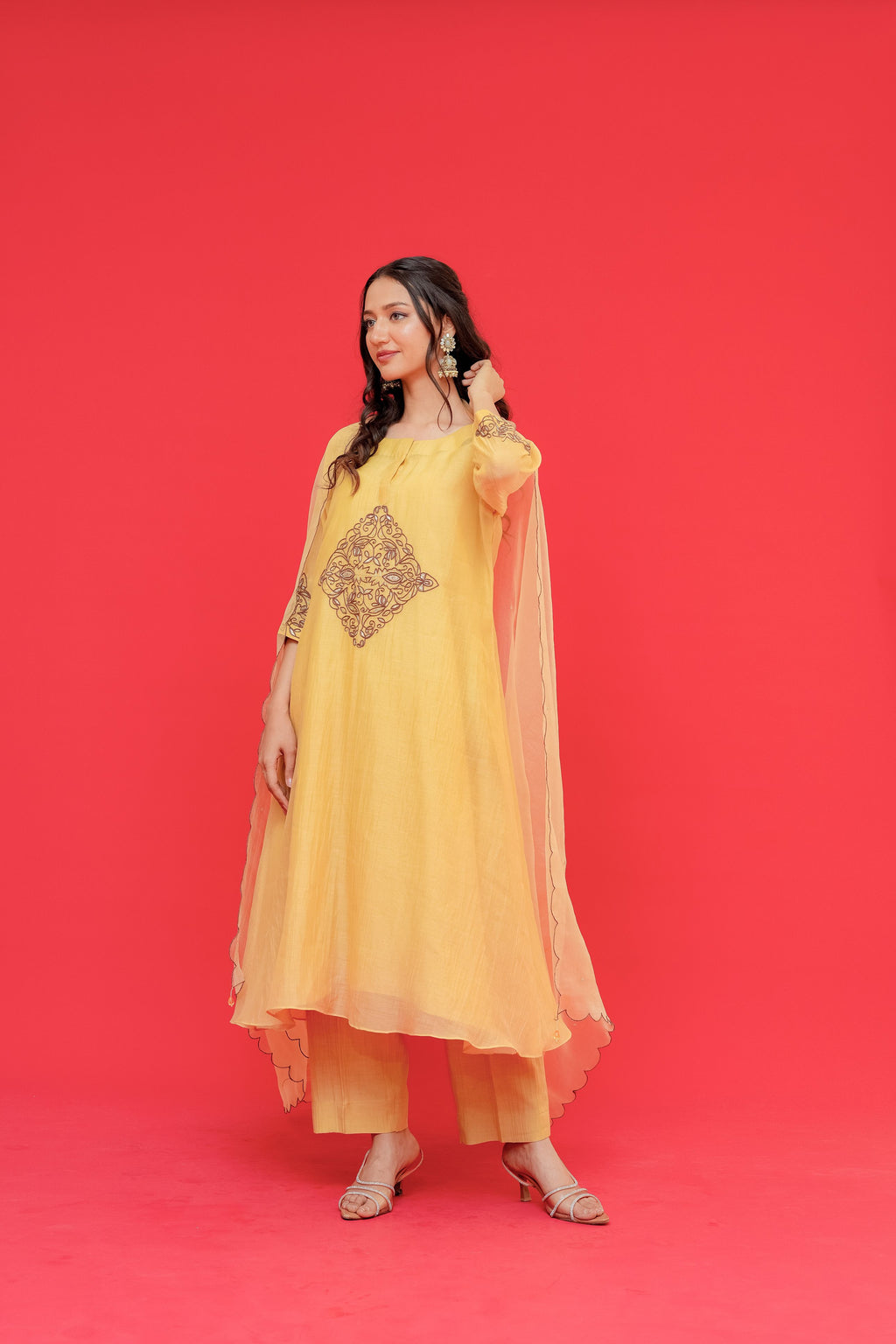 Woman wearing a yellow traditional outfit with a red background