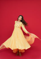 Woman in a Sunny Yellow Mul Chanderi Anarkali Set  on a red background