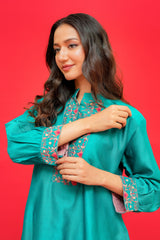 Woman wearing a teal traditional outfit with floral patterns on a red background