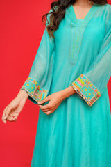Teal traditional outfit with colorful embroidery on a red background