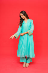 Woman wearing a turquoise traditional outfit on a red background