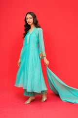 Woman wearing a turquoise traditional outfit on a red background