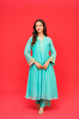 Woman wearing a light blue traditional outfit on a red background