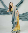 Woman wearing a yellow and blue saree with a white background