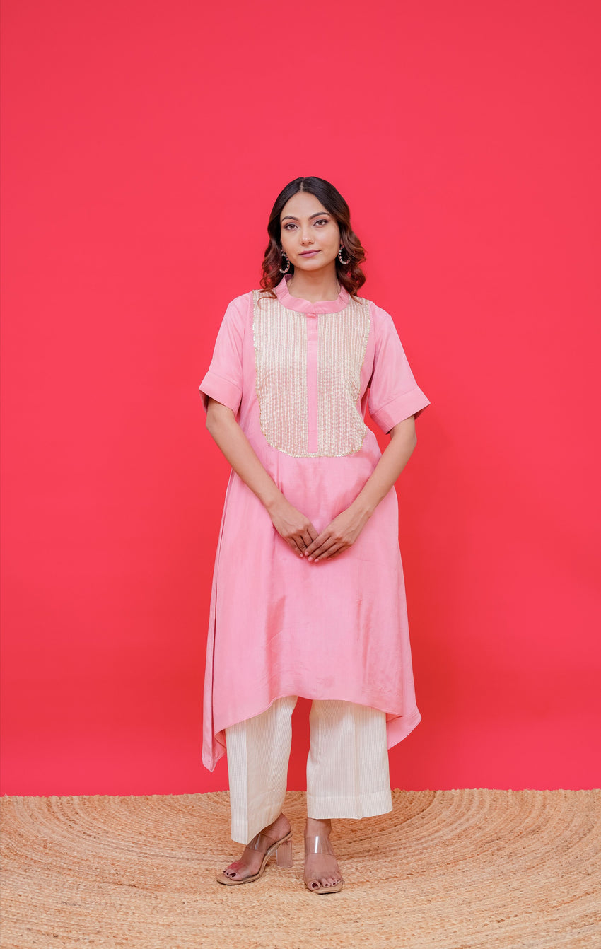 Woman wearing a pink traditional outfit against a red background