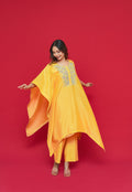 Woman wearing a yellow Yellow Chanderi Silk Kaftan Set with a red background