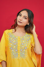 Woman wearing a Yellow Chanderi Silk Kaftan Set  against a red background