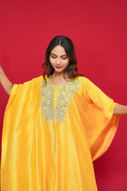 Woman wearing a Yellow Chanderi Silk Kaftan Set against a red background