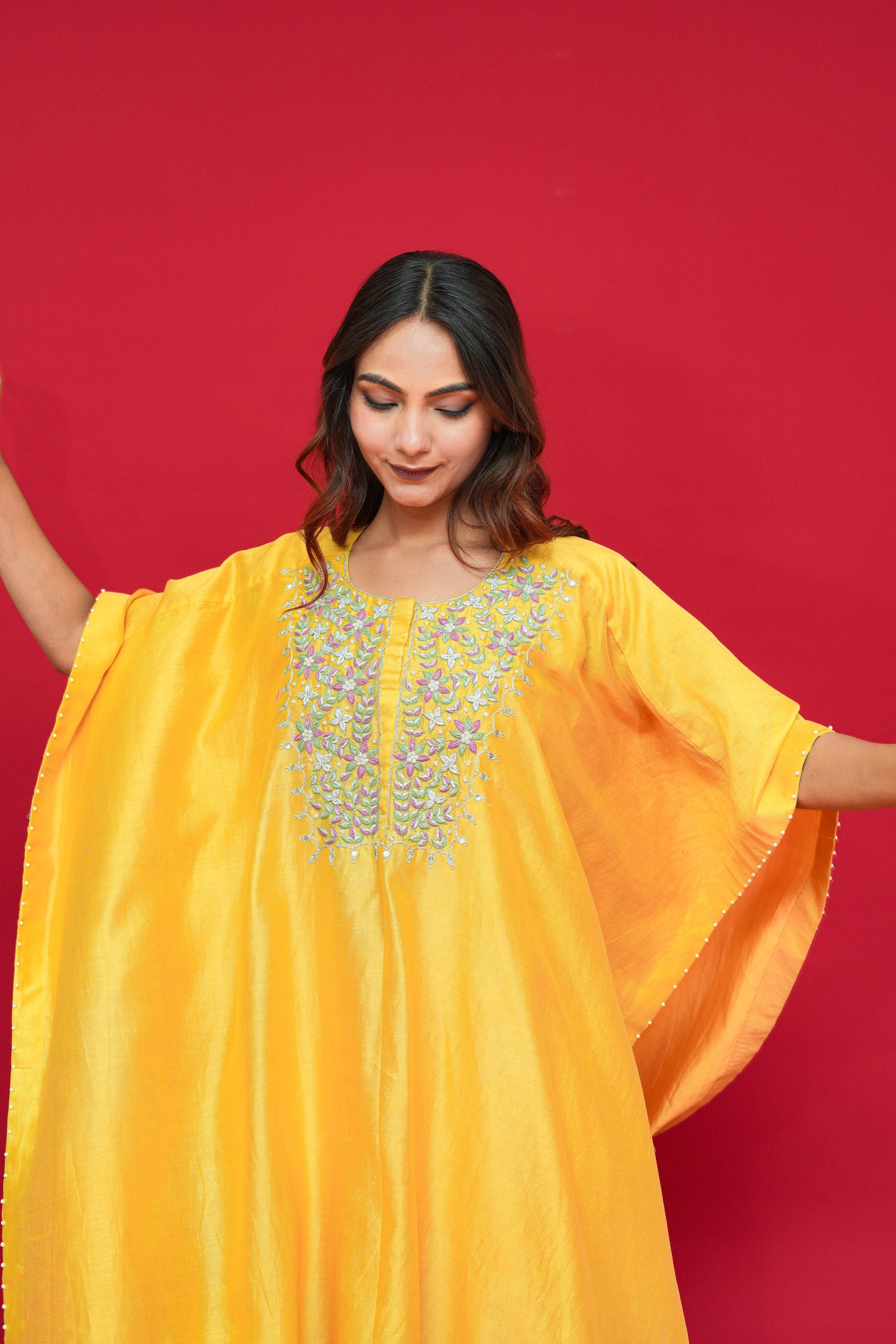 Woman wearing a Yellow Chanderi Silk Kaftan Set against a red background