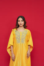 Woman wearing a Yellow Chanderi Silk Kaftan Set  against a red background